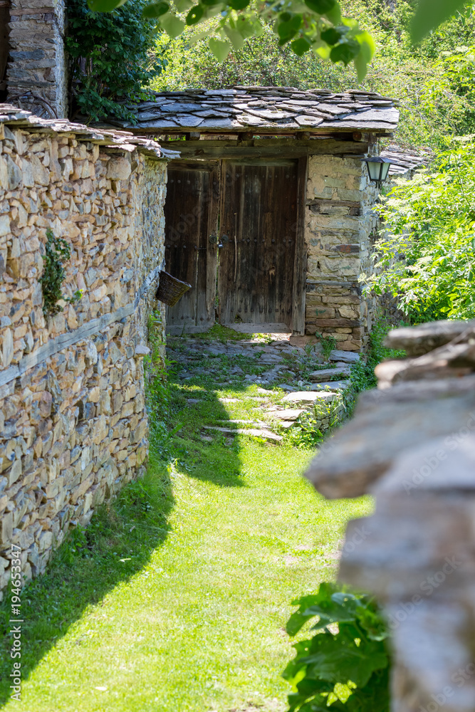 Narrow street covered with grass between old stone walls Narrow street covered with grass between old stone walls