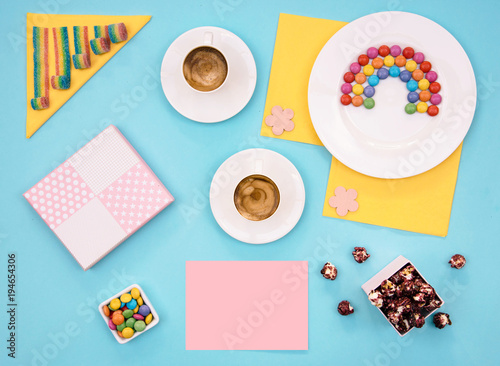 Colorful still life with sweets and present on blue background.