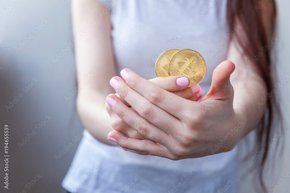 Cryptocurrency golden bitcoin coin in woman hand. Electronic virtual money for web banking and international network payment. Symbol of crypto currency Cryptocurrency golden bitcoin coin in woman hand. Electronic virtual money for web banking and international network payment. Symbol of crypto currency