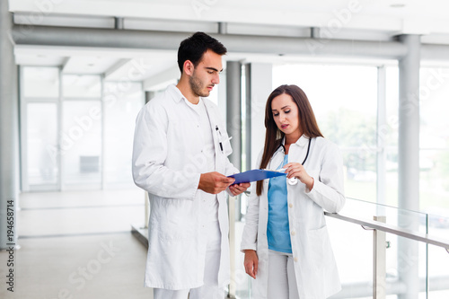 Young colleagues talking about paperwork