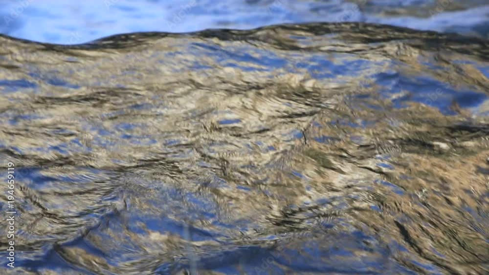 background of colorful and iridescent reflections on the surface of running water
