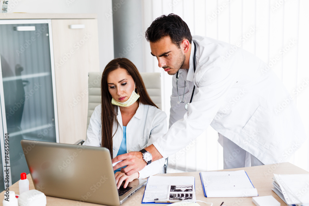 Beautiful nurse and young doctor work on laptop Beautiful nurse and young doctor work on laptop