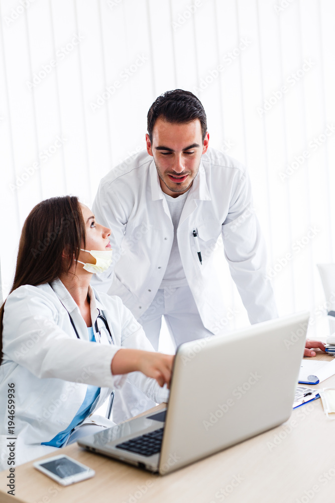 Beautiful nurse and young doctor works on laptop Beautiful nurse and young doctor works on laptop