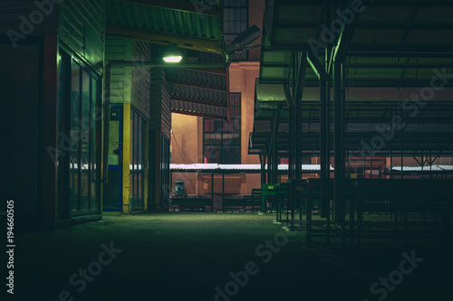 Central marketplace at night time. Isolated territory filled with trading stands and lighten by city lights. Spooky and abandoned atmosphere in urban market territory. 