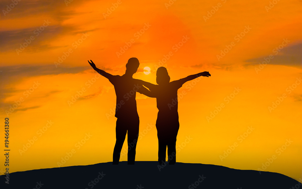 Man and woman in love. They are standing and see the sun set. Woman wearing a hatand man Man hugging woman.Photo concept Silhouette and love. 