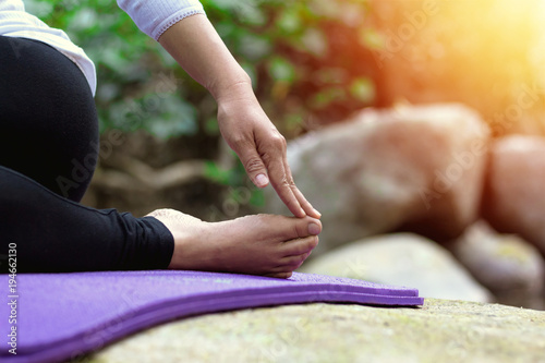 Close up hands and foot. Woman doing yoga on the stone.Healthy and Yoga Concept