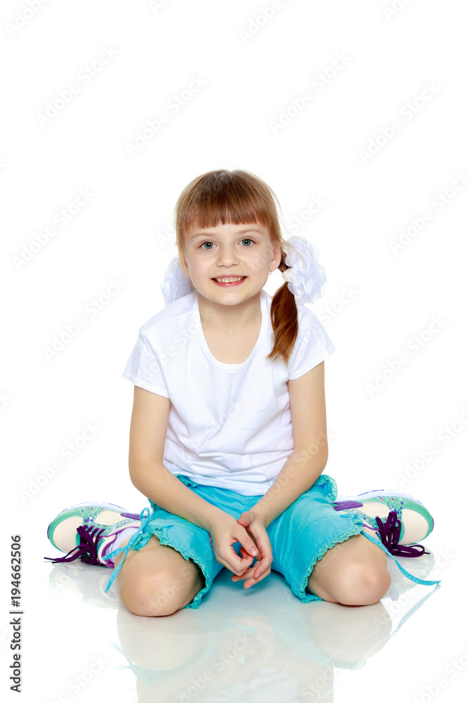 A little girl in a white T-shirt and shorts. A little girl in a white T-shirt and shorts.
