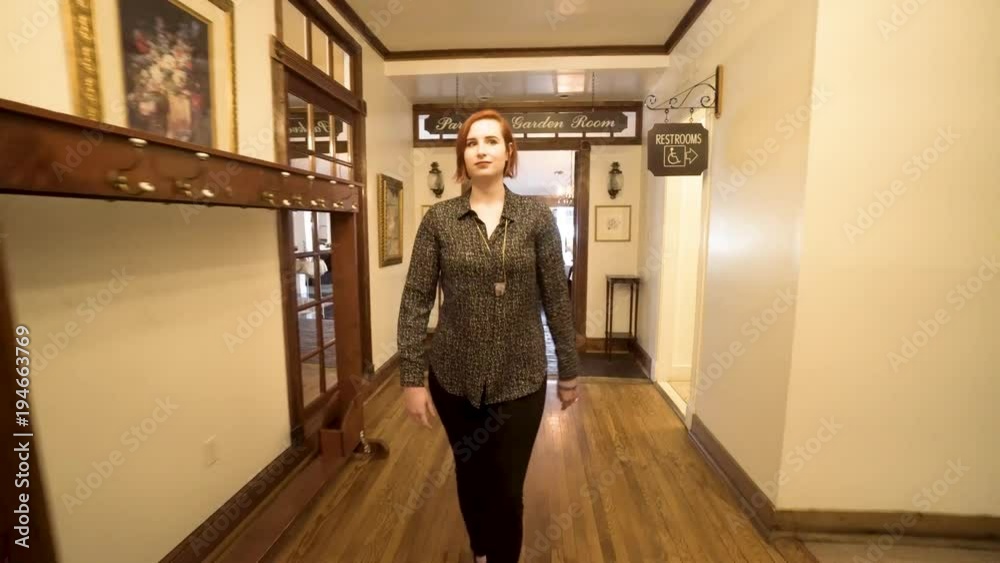 Pretty woman walks through the halls of a historic inn through the restaurant and reception areas. Pretty woman walks through the halls of a historic inn through the restaurant and reception areas.