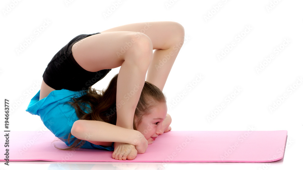 The little gymnast perform an acrobatic element on the floor. The little gymnast perform an acrobatic element on the floor.