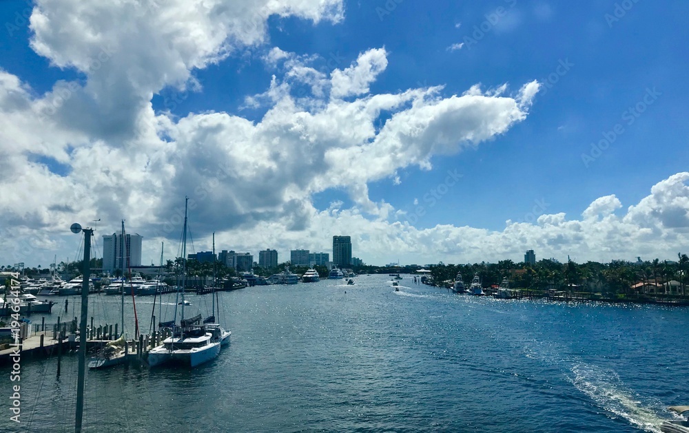 Impressive Las Olas Boulevard with clear water, sailing boats, luxurious houses and a beautiful blue sky with white clouds in Fort Lauderdale - Florida (USA)