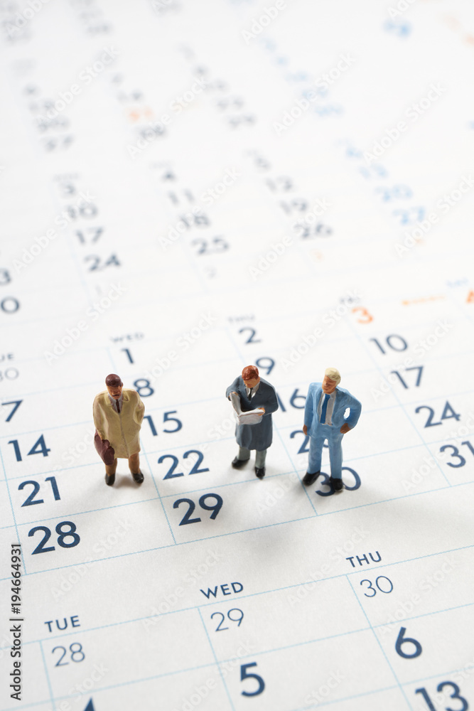 カレンダーとビジネスマンのミニチュア人形