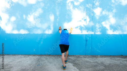 Attractive young man stretching on the track before running