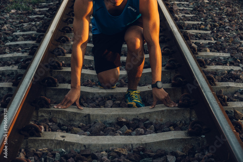 Close up the runner start from run on railroad tracks with dramatic tone, Sunset running in the evening
