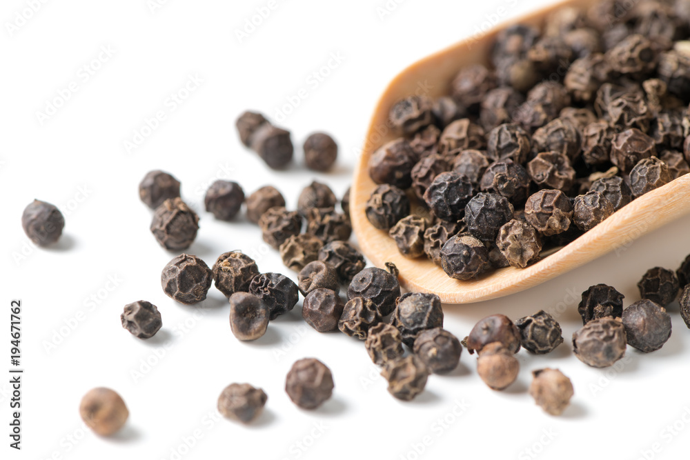 Dry black pepper on wood scoop isolated Dry black pepper on wood scoop isolated