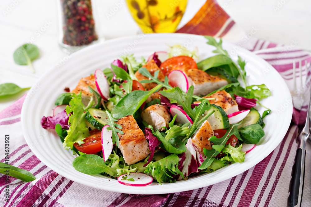 Fresh vegetable salad with grilled chicken breast   - tomatoes, cucumbers, radish and mix lettuce leaves. Chicken salad. Healthy food.