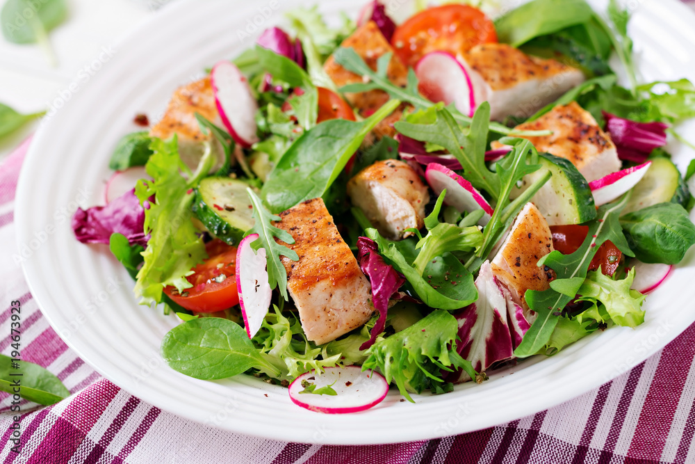 Fresh vegetable salad with grilled chicken breast   - tomatoes, cucumbers, radish and mix lettuce leaves. Chicken salad. Healthy food.