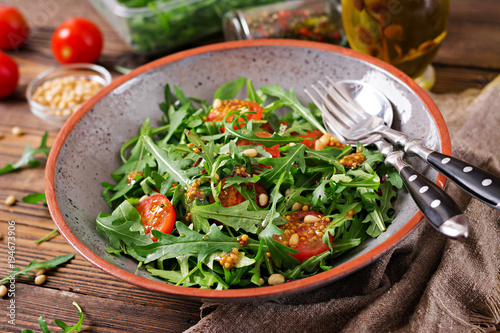 Dietary menu. Vegan cuisine. Healthy salad with arugula, tomatoes and pine nuts.