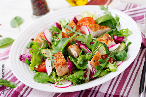 Fresh vegetable salad with grilled chicken breast   - tomatoes, cucumbers, radish and mix lettuce leaves. Chicken salad. Healthy food.