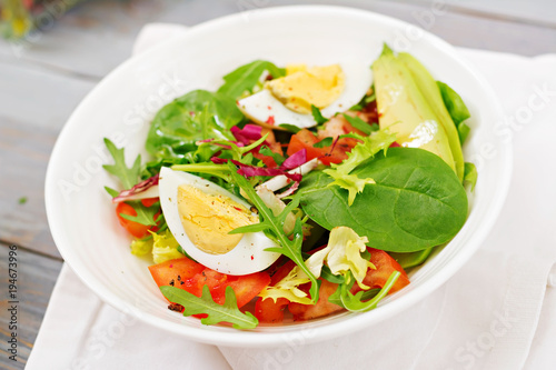 Delicious and light salad of tomatoes, eggs and a mix of lettuce leaves. Healthy breakfast.
