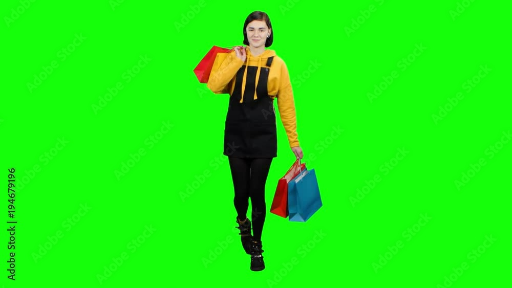 Teen is walking along the street with packages in her hands. Green screen Teen is walking along the street with packages in her hands. Green screen