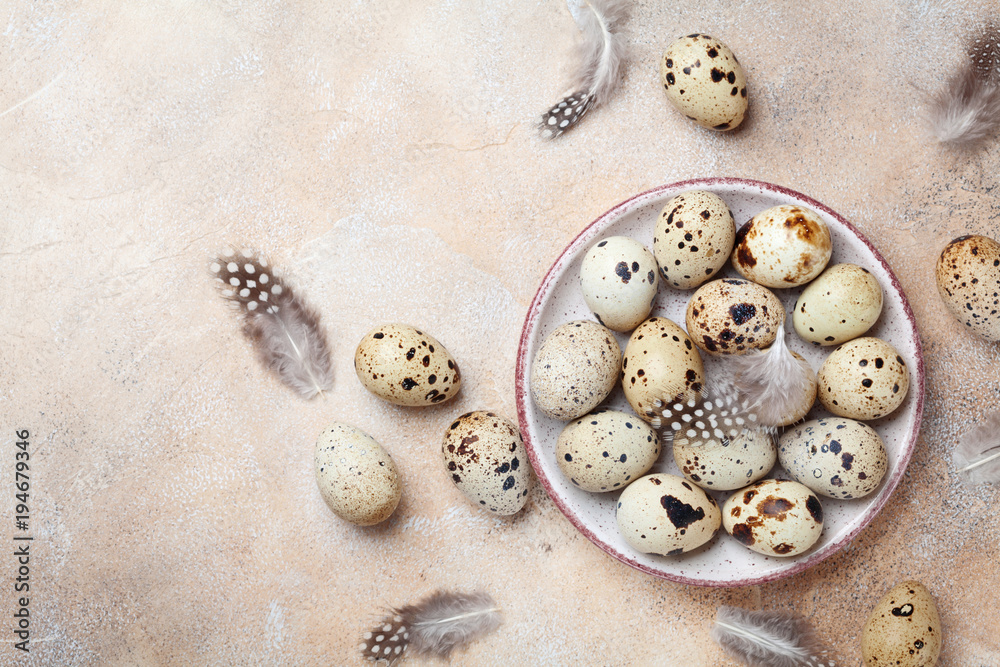 Heap of quail eggs decorated with feather. Organic food. Rustic style. Top view.