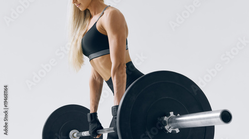 Close-up photo of attractive fitness model workout with barbell Sporty woman with perfect shoulders, biceps and triceps muscles Shot on white background