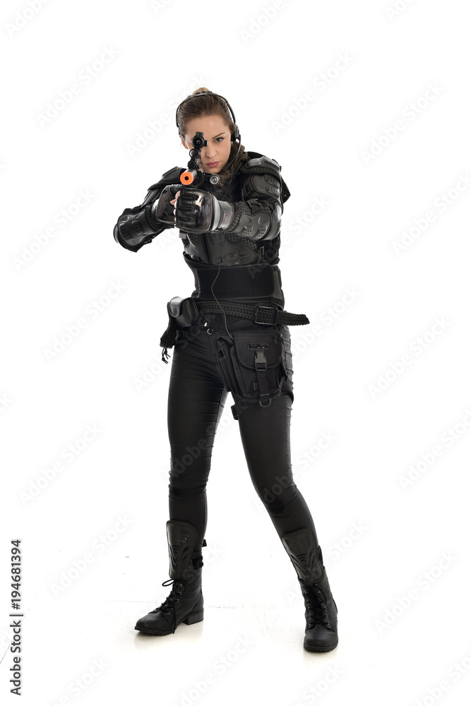 full length portrait of female soldier wearing black tactical armour, holding a rifle gun, isolated on white studio background. full length portrait of female soldier wearing black tactical armour, holding a rifle gun, isolated on white studio background.