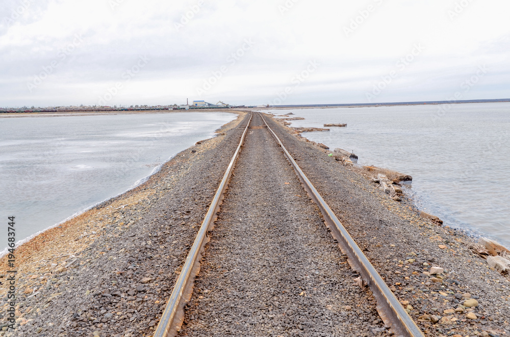 old rusty railroad tracks on gravel embankment at salt mining site  Lake Baskunchak, Astrakhan region, Russia