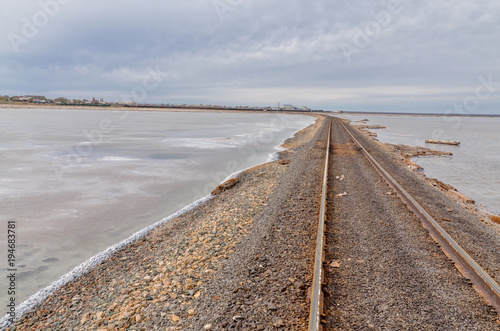old rusty railroad tracks on gravel embankment at salt mining site  Lake Baskunchak, Astrakhan region, Russia © ssmalomuzh