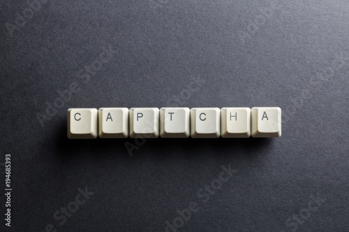 Word captcha made using computer keyboard buttons on a black background. Compact disk. IT technology concept.