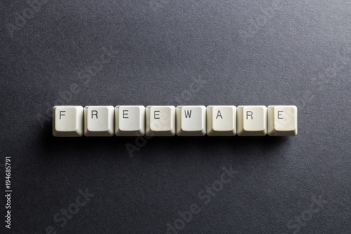 Word freeware made using computer keyboard buttons on a black background. No monetary cost free software. IT technology concept.