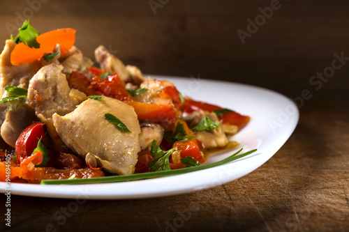 Plate with chicken stew with red pepper and herbs