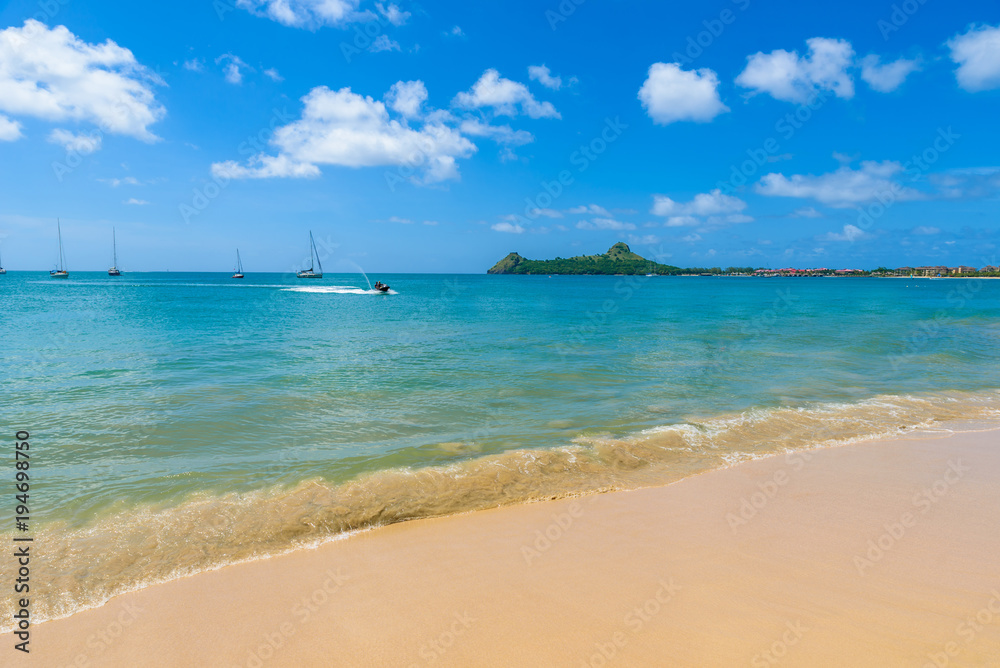 Obraz premium Reduit Beach - Tropical coast on the Caribbean island of St. Lucia. It is a paradise destination with a white sand beach and turquoiuse sea.