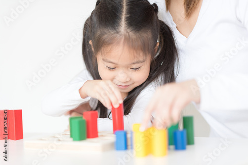 Little girl playing blocks with mother. Educational toys for preschool and kindergarten child. Little girl build block toys at home or daycare.Education concept.