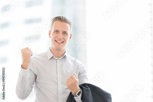 Handsome and Confident Businessman Carry his Balck Jecket Suit over his Sholder against Blurred City Center.  photo