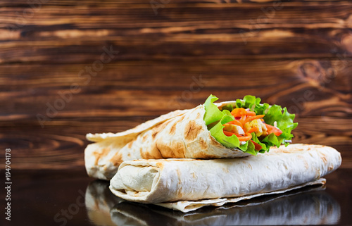 Delicious shawarma sandwich on wooden background