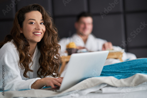 Couple relaxing and working from hotel room
