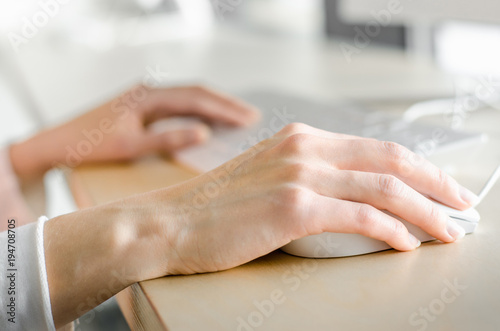 Close up business woman top view working personal computer sitting wooden table desktop office window skyscraper. Female hands using smart phone typing computer keyboard. 