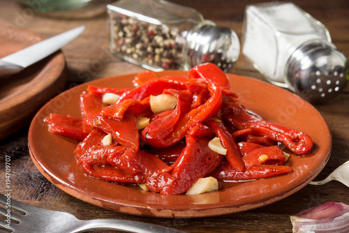 strips of fried red pepper in clay dish on rustic wood