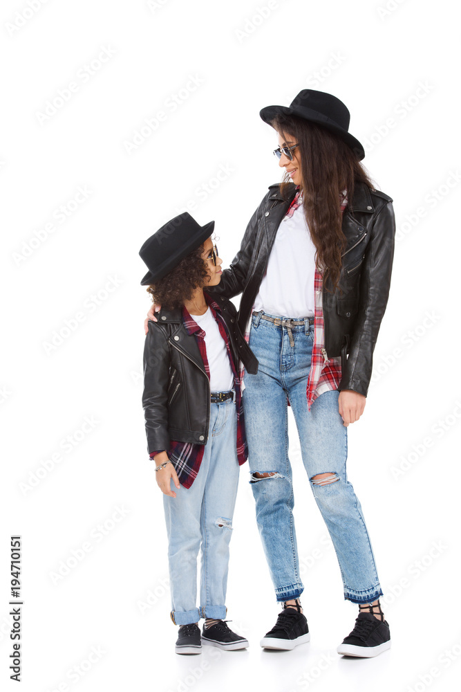 stylish mother and daughter in hats and sunglasses looking at each other isolated on white stylish mother and daughter in hats and sunglasses looking at each other isolated on white