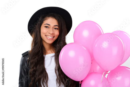 happy young woman in leather jacket with balloons isolated on white