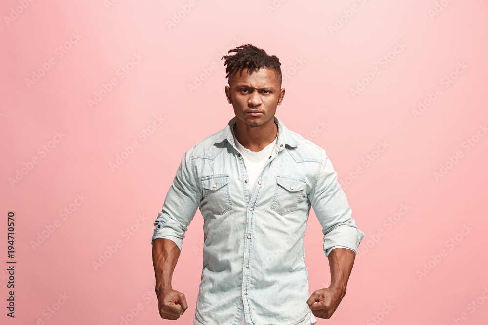 The young emotional angry afro man screaming on pink studio background The young emotional angry afro man screaming on pink studio background