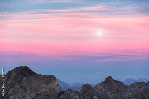 Vollmond über Berglandschaft während Sonnenuntergang photo