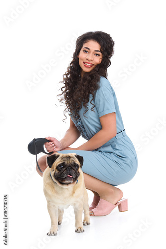attractive young woman with leashed pug isolated on white