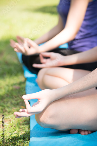 Close-up view of young woman doing yoga in park