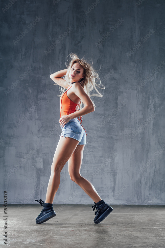 Young beautiful female dancer is posing in the studio