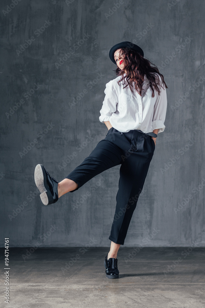 Young beautiful female dancer is posing in the studio