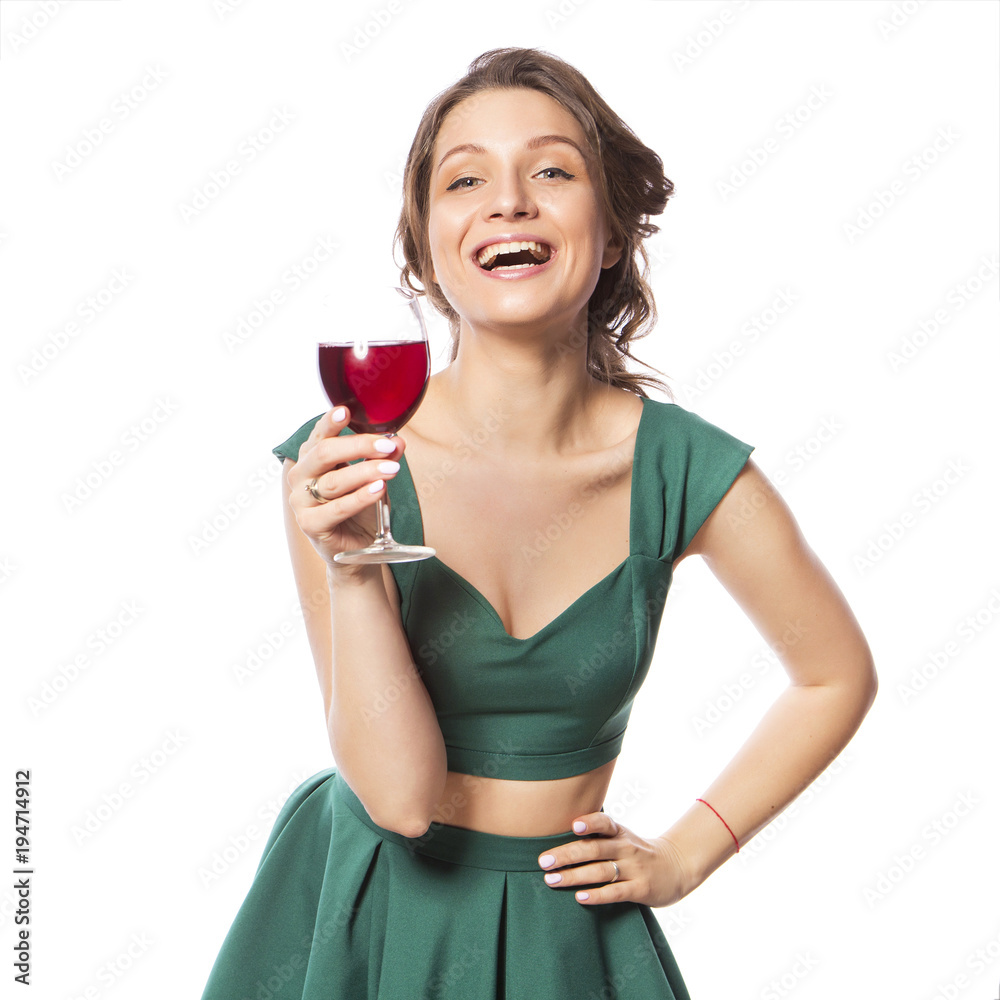 Brunette pretty beautiful caucasian woman in green festive party holiday dress drinking wine from a glass. Isolated white background Brunette pretty beautiful caucasian woman in green festive party holiday dress drinking wine from a glass. Isolated white background