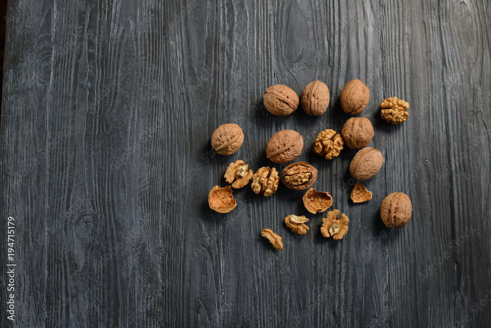 Walnut kernels and whole walnuts on rustic old wooden table Walnut kernels and whole walnuts on rustic old wooden table