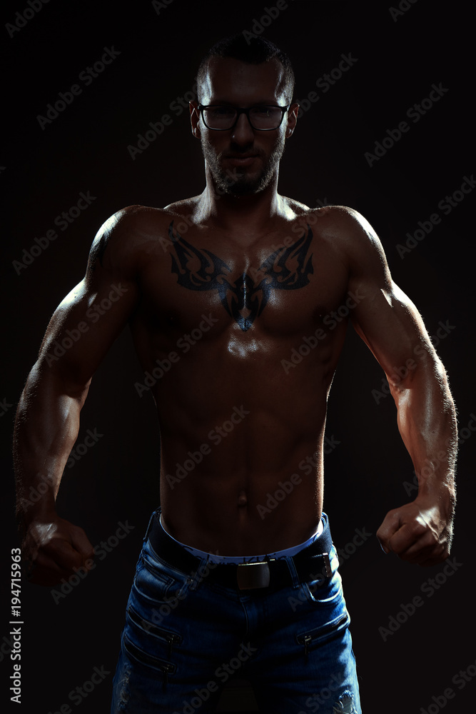 Muscular man posing in studio on dark background